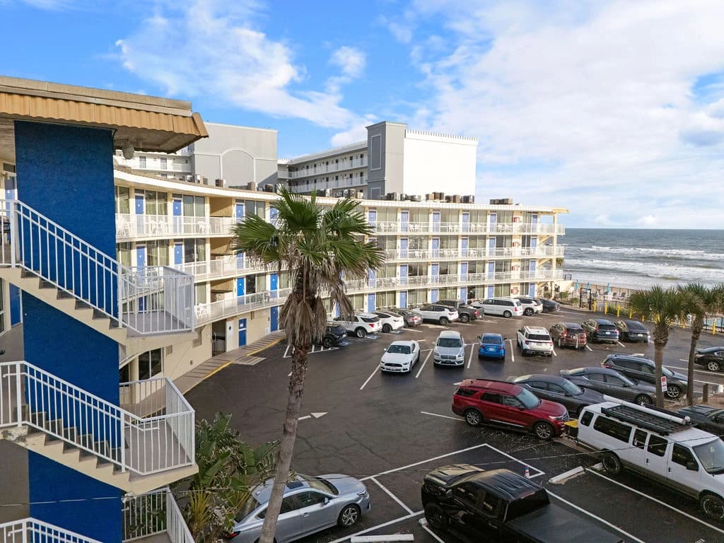 Sandy beach shoreline with gentle waves during a calm sunset.