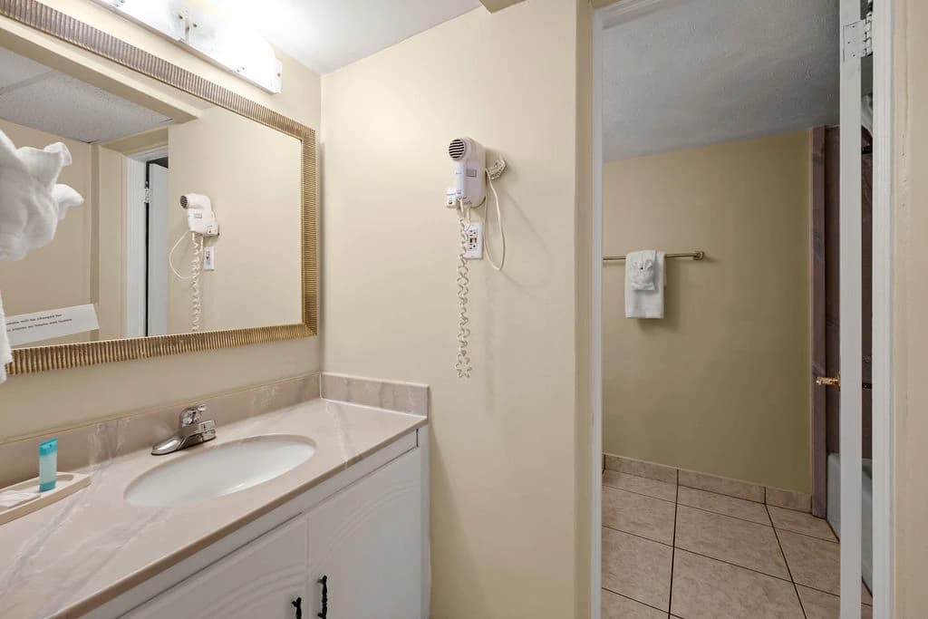Outrigger Beach Club entrance sign with palm tree logo and covered driveway.