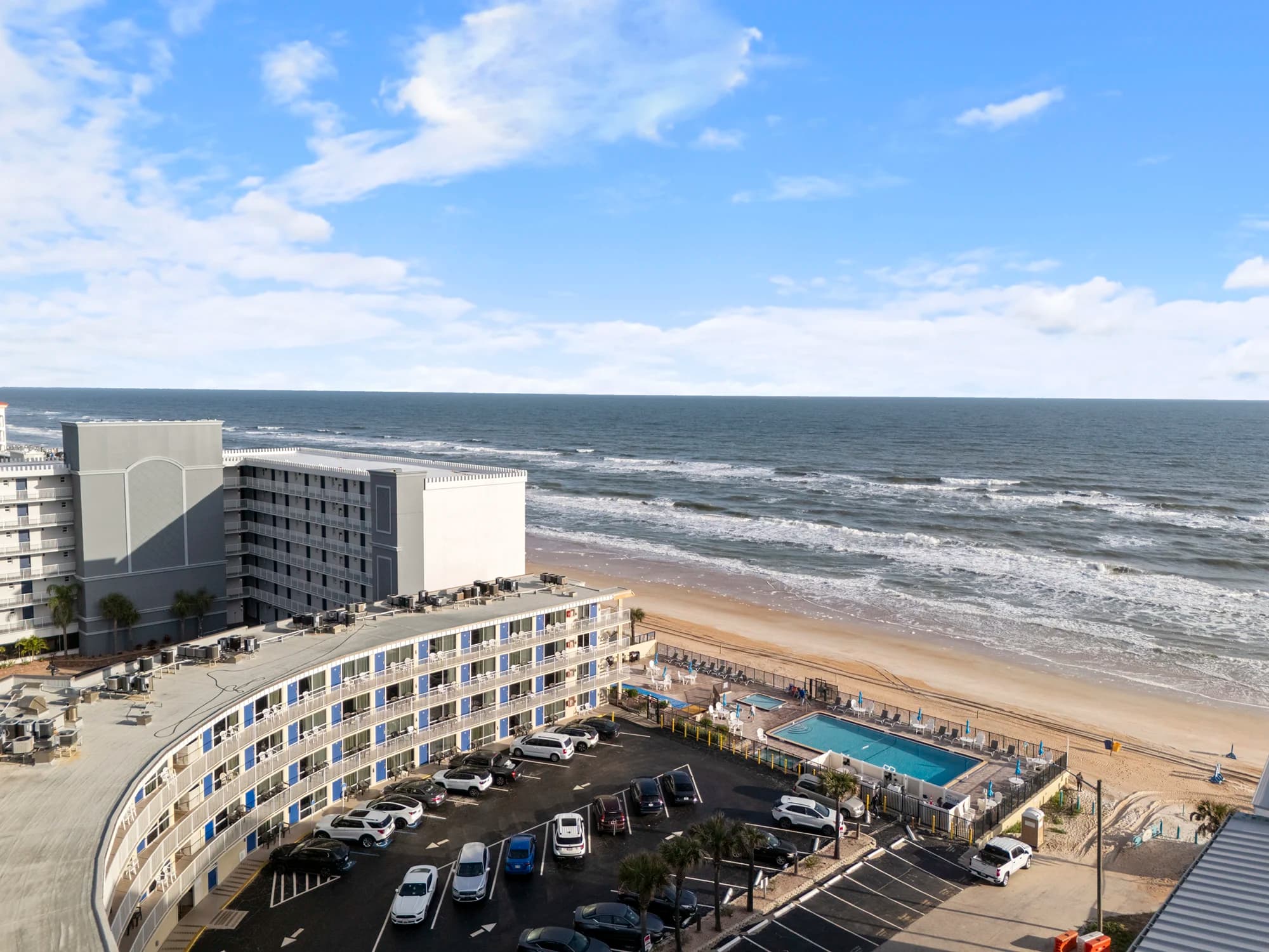 Sandy beach shoreline with gentle ocean waves under a clear blue sky.